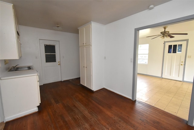 kitchen with ceiling fan, sink, dark hardwood / wood-style flooring, washer / clothes dryer, and white cabinets