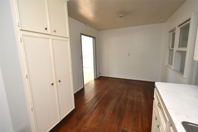 kitchen featuring dark hardwood / wood-style flooring and white cabinetry