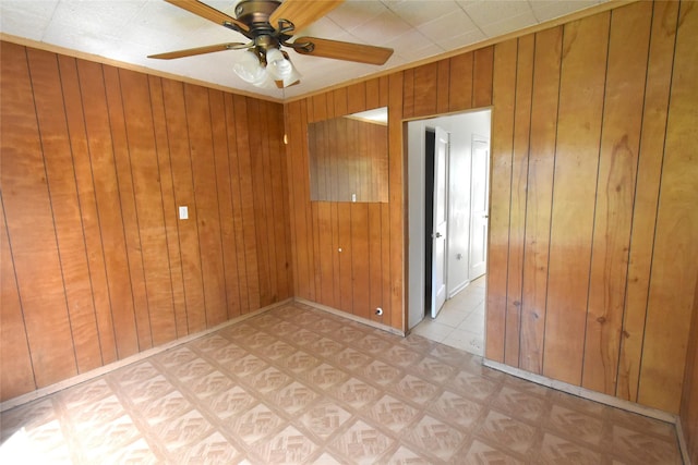 empty room with wood walls and ceiling fan