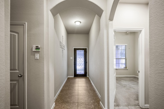 hall with carpet flooring and a textured ceiling