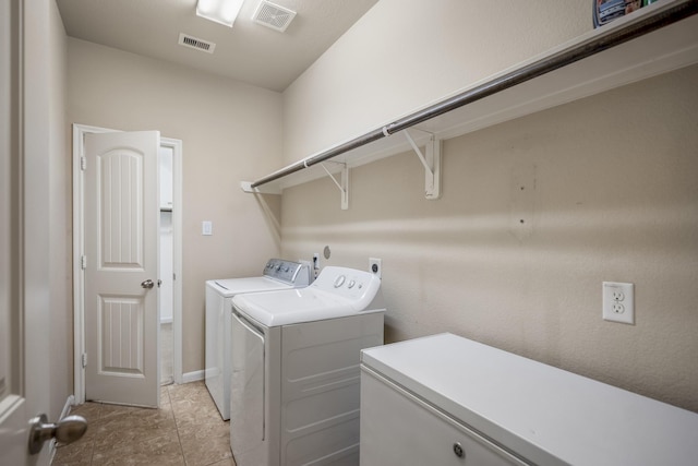 laundry area with light tile patterned floors and washer and dryer