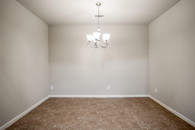 spare room featuring an inviting chandelier