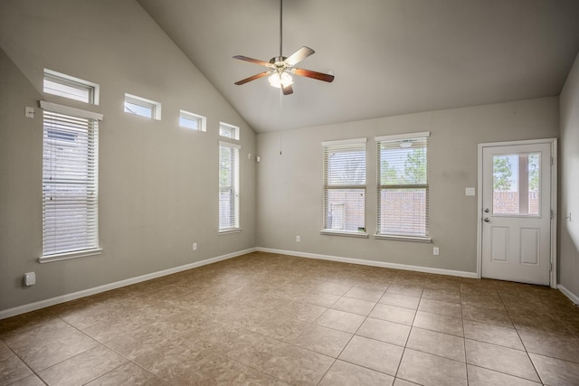 spare room featuring light tile patterned floors, high vaulted ceiling, a wealth of natural light, and ceiling fan