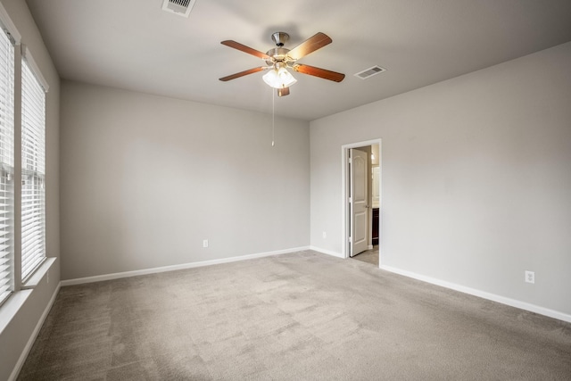 carpeted empty room featuring ceiling fan and a wealth of natural light