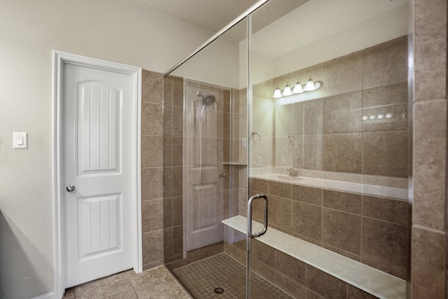 bathroom featuring tile patterned flooring and an enclosed shower