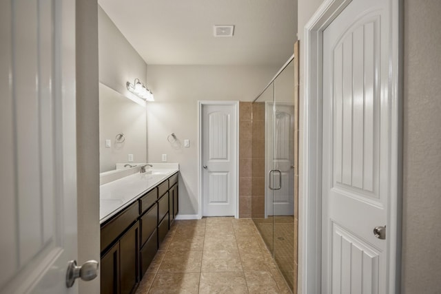 bathroom with tile patterned floors, vanity, and a shower with shower door