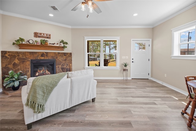 living room featuring plenty of natural light, light hardwood / wood-style floors, and ornamental molding