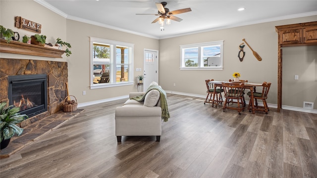 sitting room featuring ceiling fan, dark hardwood / wood-style flooring, ornamental molding, and a fireplace