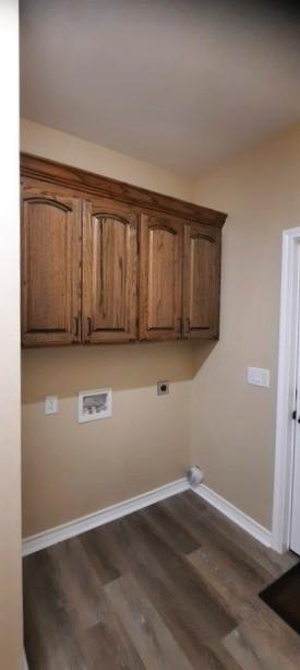 laundry room featuring electric dryer hookup, dark hardwood / wood-style floors, cabinets, and washer hookup