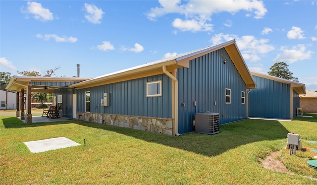 view of side of property featuring ceiling fan, a patio, central AC unit, and a lawn