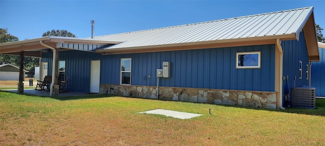 back of property with a lawn and central air condition unit