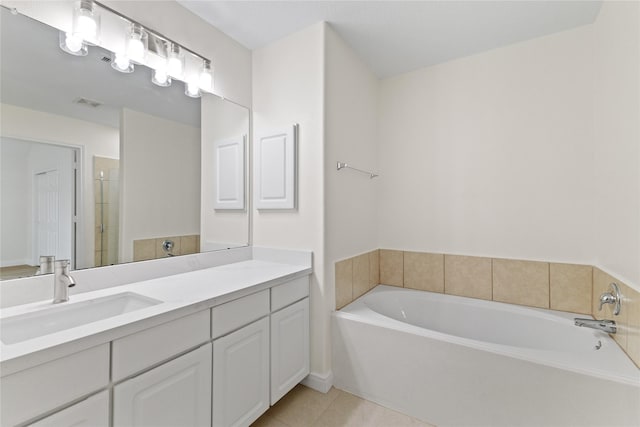 bathroom with tile patterned floors, a bathtub, and vanity