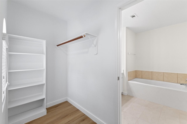 walk in closet with light wood-type flooring