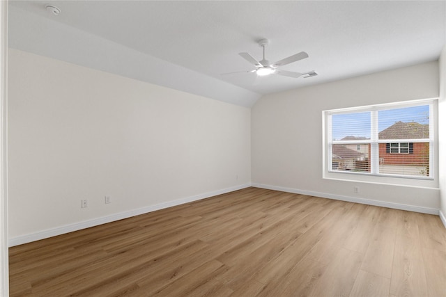 spare room with lofted ceiling, ceiling fan, and light wood-type flooring