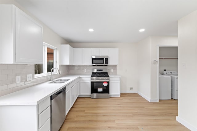 kitchen with sink, white cabinets, stainless steel appliances, and light hardwood / wood-style floors