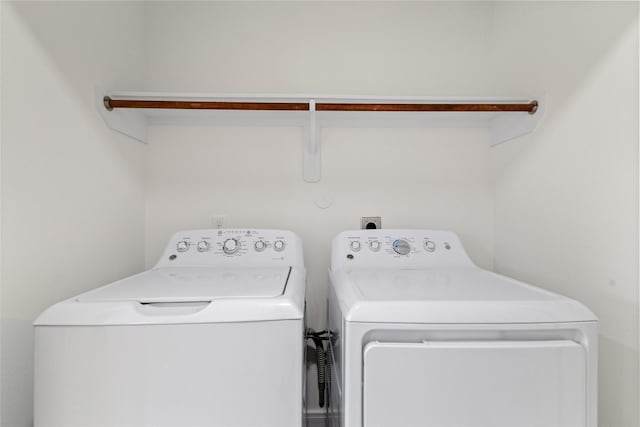 clothes washing area with washer and clothes dryer