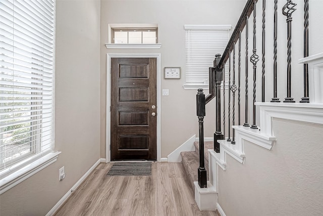 entrance foyer with light hardwood / wood-style floors and a healthy amount of sunlight