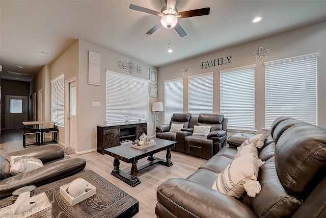 living room featuring light hardwood / wood-style flooring and ceiling fan