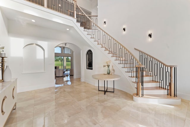 stairs with a high ceiling and french doors