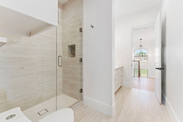 bathroom with an enclosed shower, vanity, tile patterned flooring, and toilet