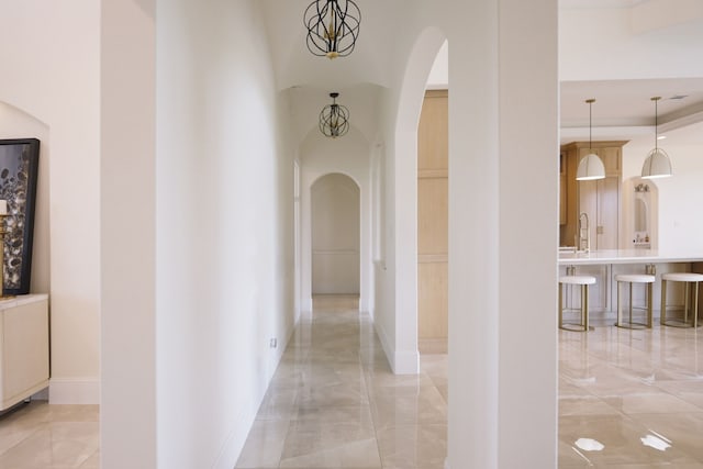 corridor with sink and a chandelier