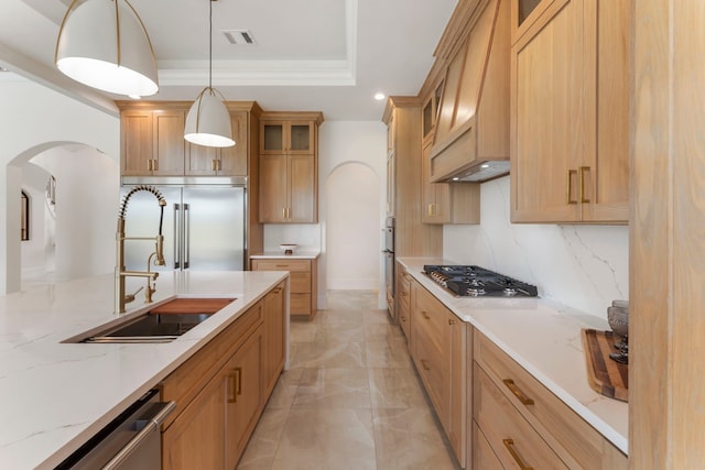 kitchen with premium range hood, a raised ceiling, decorative backsplash, hanging light fixtures, and stainless steel appliances