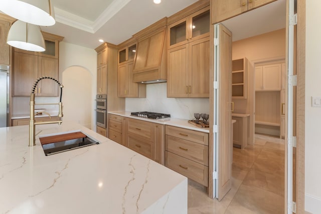 kitchen with decorative light fixtures, sink, crown molding, stainless steel appliances, and light stone counters