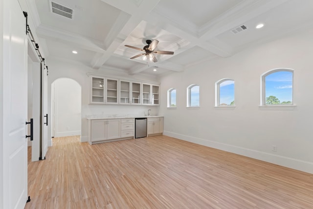 kitchen featuring a barn door, dishwasher, beamed ceiling, white cabinetry, and light hardwood / wood-style flooring