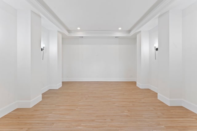 basement featuring crown molding and light hardwood / wood-style floors