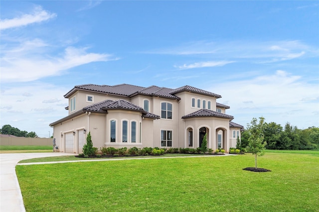 mediterranean / spanish home with a front yard and a garage