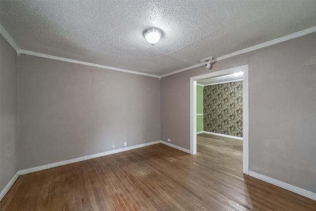 spare room with hardwood / wood-style floors, a textured ceiling, and ornamental molding