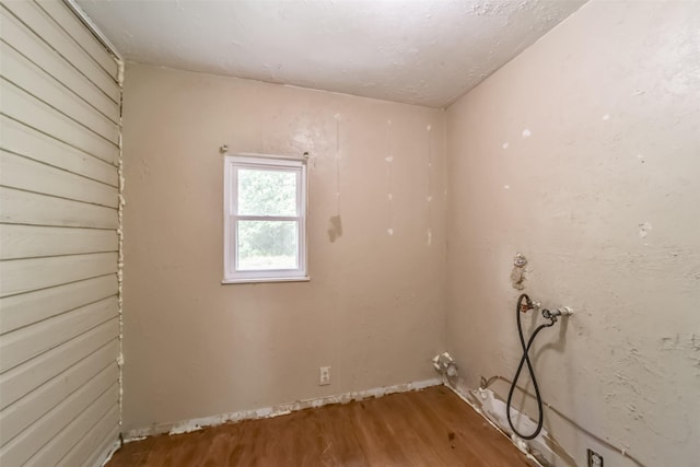 clothes washing area with hardwood / wood-style floors