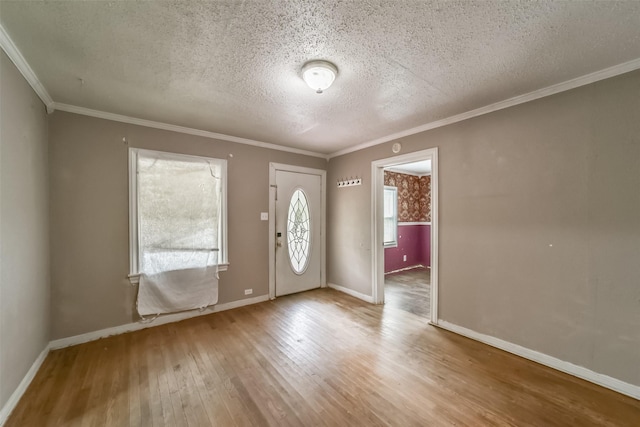 foyer featuring wood-type flooring, a textured ceiling, and ornamental molding