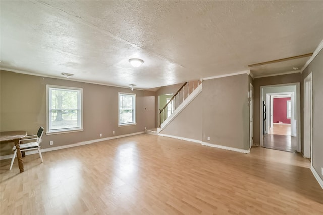 interior space featuring ornamental molding, a textured ceiling, and light hardwood / wood-style flooring