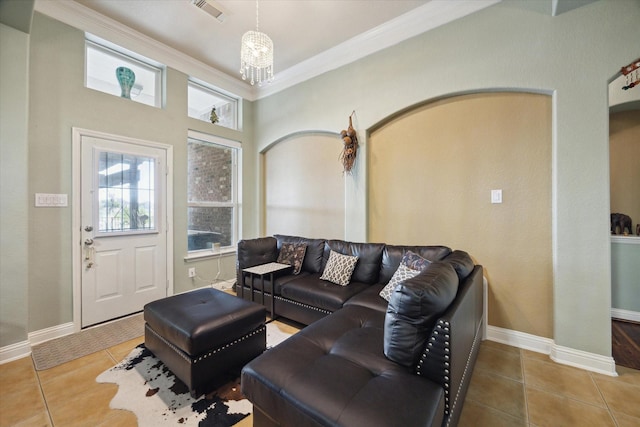 living room with tile patterned floors, crown molding, and a chandelier