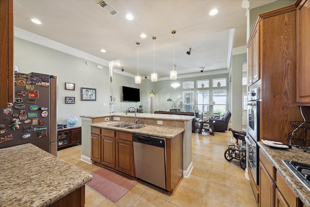 kitchen with sink, an island with sink, decorative light fixtures, appliances with stainless steel finishes, and ornamental molding