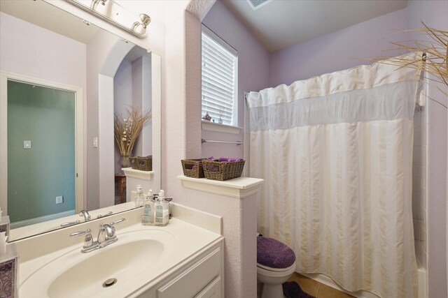 bathroom featuring tile patterned flooring, vanity, and toilet