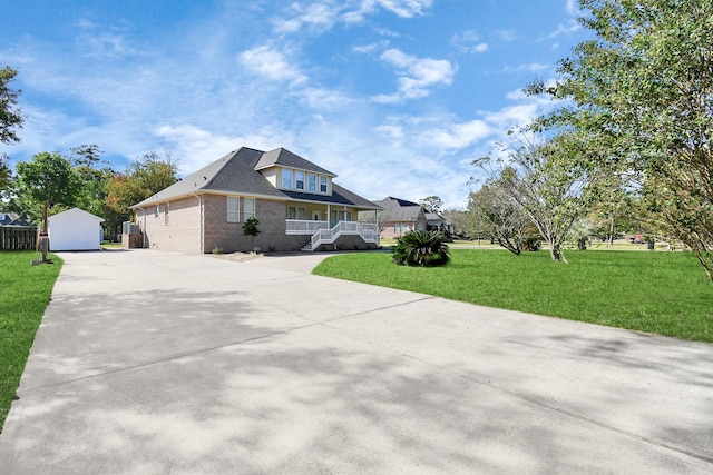 view of front of property featuring a garage, covered porch, an outbuilding, and a front lawn