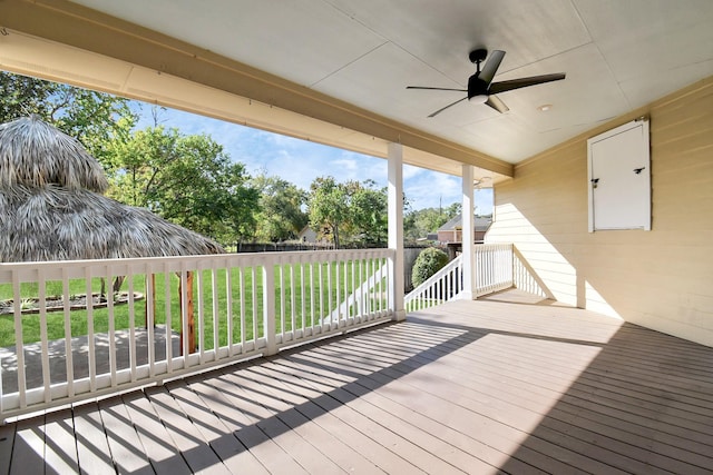 wooden deck with a lawn and ceiling fan