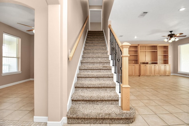 stairway featuring tile patterned flooring and ceiling fan