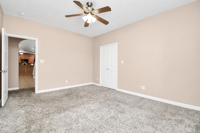 unfurnished bedroom featuring ceiling fan, carpet floors, and a closet