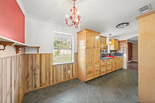 kitchen with pendant lighting, ornamental molding, backsplash, and an inviting chandelier