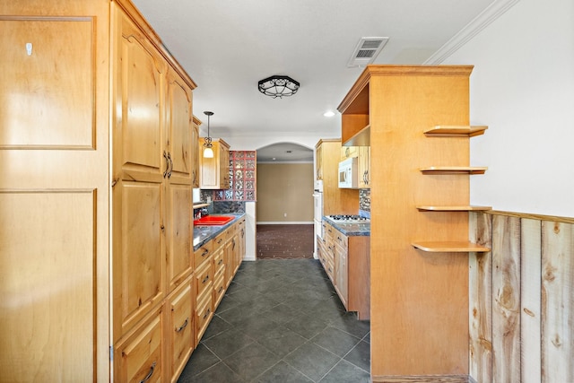 kitchen featuring dark tile patterned flooring, ornamental molding, hanging light fixtures, and light brown cabinetry