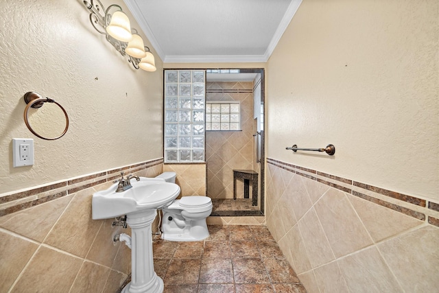 bathroom with toilet, tile walls, and crown molding