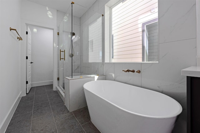 bathroom with tile patterned floors, tile walls, and shower with separate bathtub