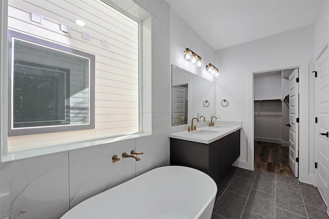 bathroom with tile patterned floors, vanity, and a bath