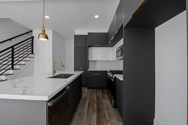 kitchen with stainless steel appliances, dark wood-type flooring, sink, pendant lighting, and white cabinets