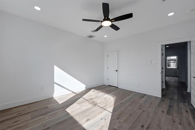 unfurnished room with ceiling fan and dark wood-type flooring