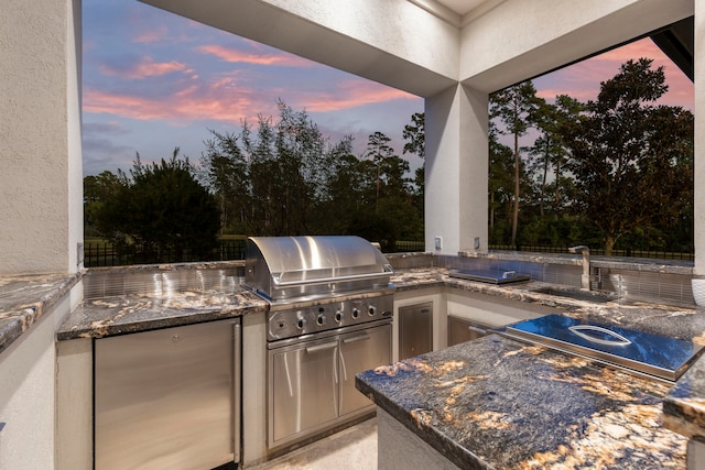 patio terrace at dusk with area for grilling and sink