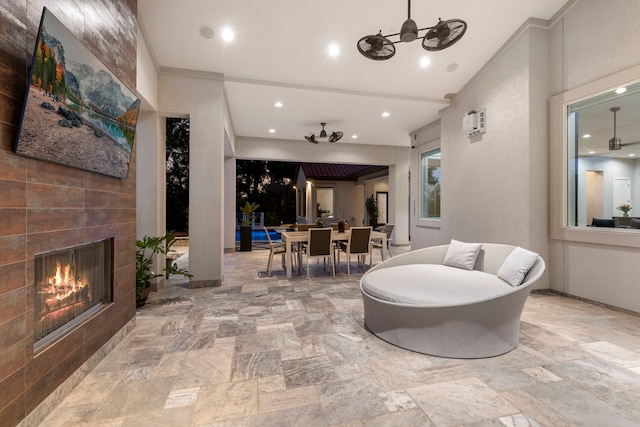 view of patio / terrace featuring ceiling fan and a tiled fireplace